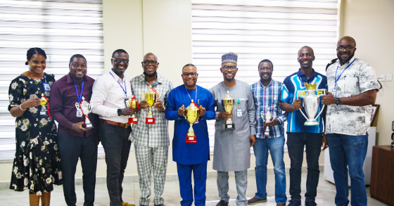 IHVN Chief Operating Officer/Managing Director, Dr Charles Olalekan Mensah, IHVN Director Finance and Administration, Mr Olu Alabi flanked by staff displaying trophies won by the Institute at the 2022 Federation of International Development Agency Football Tournament (FIDAF)